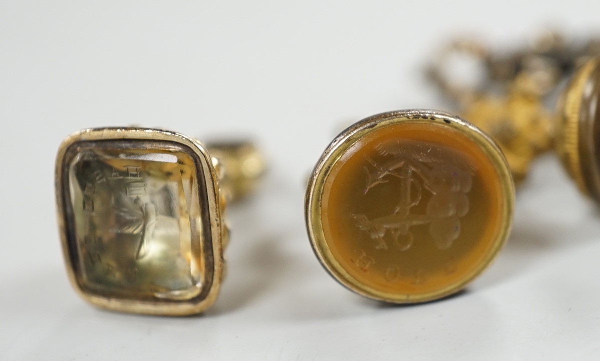 A 19th century yellow metal overlaid and amethyst set fob seal, the matrix carved with a phoenix, 20mm, together with four 19th century gold plated and chalcedony or citrine set fob seals.